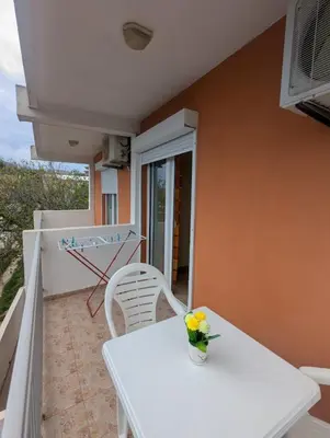 a vase of flowers on a white table on a balcony at Montana Mare in Sutomore