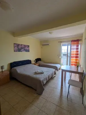 a bedroom with two beds and a table and a desk at Montana Mare in Sutomore