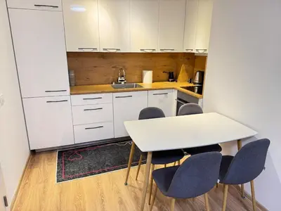 a kitchen with a white table and four chairs at ANI apartment 1 in Ulcinj