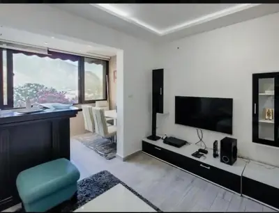 a living room with a television and a chair in it at Holiday 1 in Dobrota