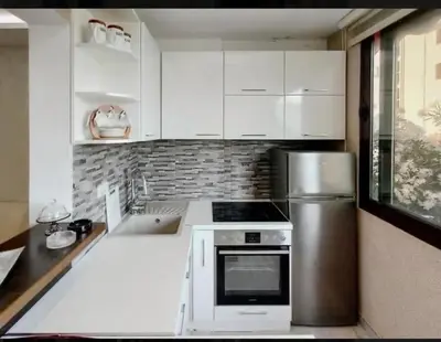 a kitchen with white cabinets and a stainless steel refrigerator at Holiday 1 in Dobrota