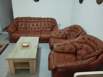 a living room with two leather chairs and a coffee table at Apartment Boksi in Ulcinj