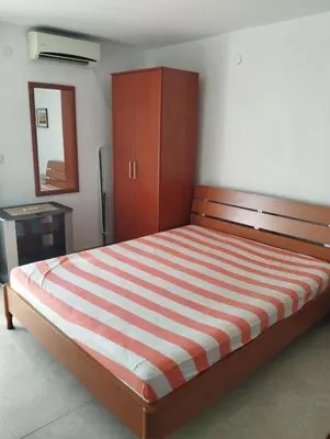 a bedroom with a bed and a cabinet and a mirror at Apartment Boksi in Ulcinj