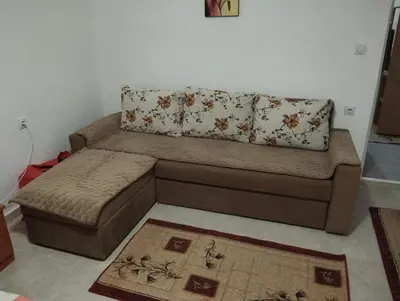 a brown couch with a pillow on top of it at Apartment Boksi in Ulcinj