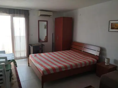 a bedroom with a bed with a red and white stripes at Apartment Boksi in Ulcinj