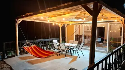 a hammock on a patio with a table and chairs at Kutak prirode in Njeguši