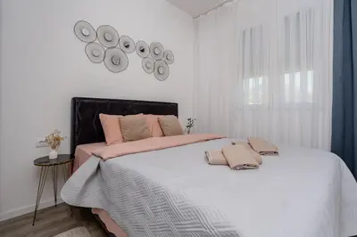 a bedroom with a bed with pink pillows on it at Alpha Neo in Bar