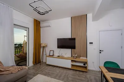 a living room with a flat screen tv on a wall at Alpha Neo in Bar