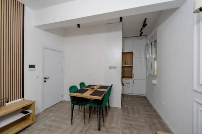 a dining room with a table and green chairs at Alpha Neo in Bar