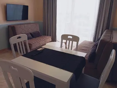 a living room with a table and chairs and a couch at Apartman Zefir Ulcinj in Ulcinj