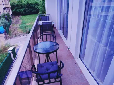 a balcony with three chairs and a table on it at Apartman Zefir Ulcinj in Ulcinj