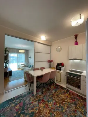 a kitchen with a table and a living room at Ekaterina2BD in Becici
