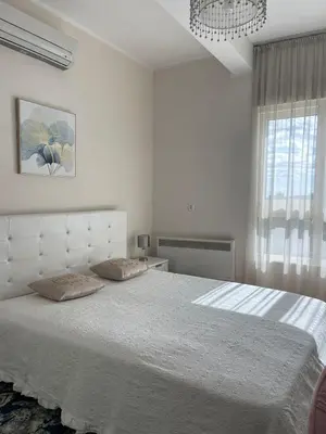 a white bedroom with a large bed with two pillows at Ekaterina2BD in Becici