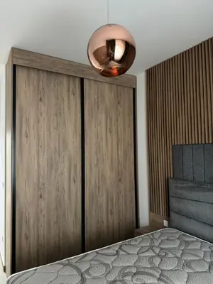 a bedroom with a bed and a large wooden wall at Ekaterina3VA in Becici