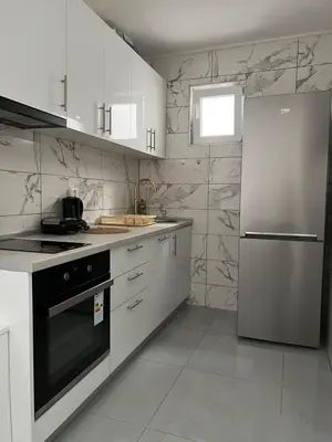a kitchen with white cabinets and a stainless steel refrigerator at Nelaa in Sutomore