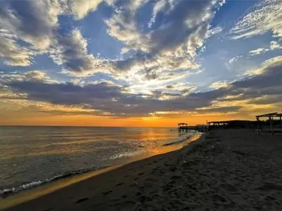a beach with a cloudy sky and the ocean at Apartment Djakonovic Mladen in Ulcinj