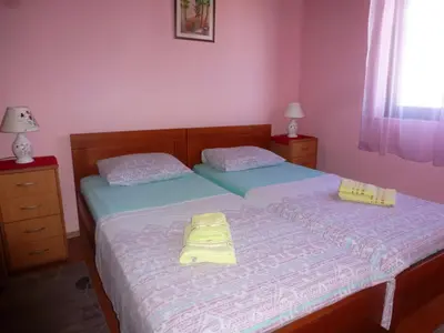 two twin beds in a room with pink walls at Apartment Djakonovic Mladen in Ulcinj