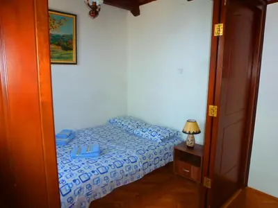 a small bedroom with a bed and a night stand at Apartment Djakonovic Mladen in Ulcinj