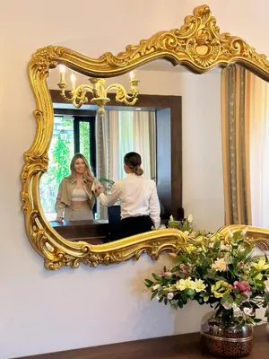 a woman sitting in front of a mirror at Hotel Opera Jaz in Budva