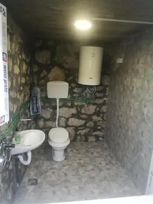 a stone bathroom with a toilet and a sink at Apartman Žabljak Crnojevića in Žabljak