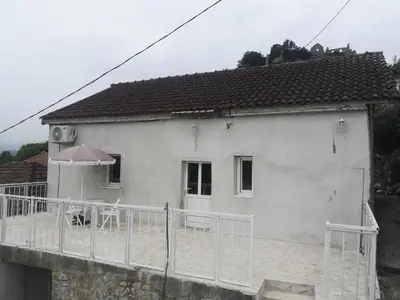 a white house with a fence in front of it at Apartman Žabljak Crnojevića in Žabljak