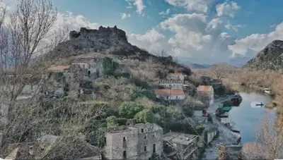 a village on a hill with a river and a castle at Apartman Žabljak Crnojevića in Žabljak