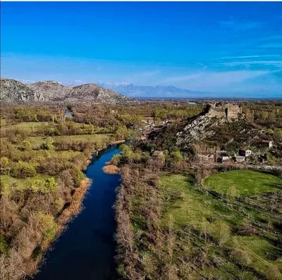 an aerial view of a river with trees and a castle at Apartman Žabljak Crnojevića in Žabljak