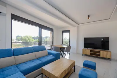 a living room with a blue couch and a tv at B1 first line apartments in Bar, Susanj
