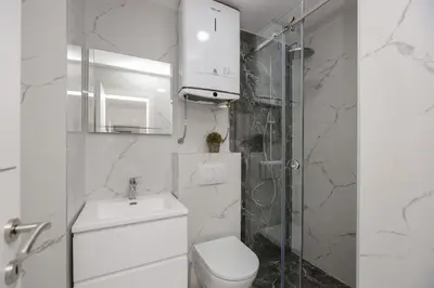 a white bathroom with a toilet and a sink at B1 first line apartments in Bar, Susanj