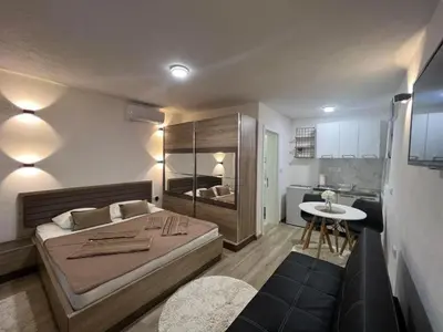 a bedroom with a large bed and a small kitchen at Rasi Sea Side Villa in Ulcinj