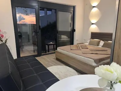 a bedroom with a bed and a table and a chair at Rasi Sea Side Villa in Ulcinj