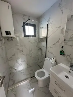 a white bathroom with a toilet and a sink at Rasi Sea Side Villa in Ulcinj