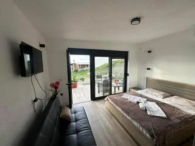 a bedroom with a large bed and a balcony at Rasi Sea Side Villa in Ulcinj