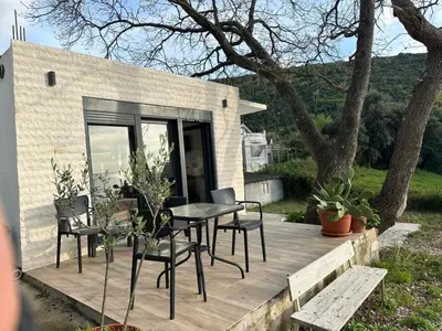 a wooden deck with a table and chairs on it at Rasi Sea Side Villa in Ulcinj