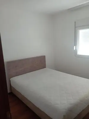 a white bed in a bedroom with a window at Niagara apartman in Podgorica