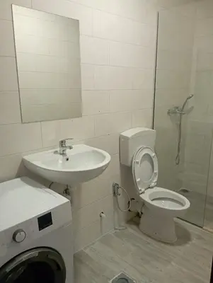 a bathroom with a toilet and a sink and a shower at Niagara apartman in Podgorica