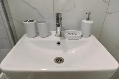 a white sink with three cups on top of it at Big Family apartment - 3BR in Budva