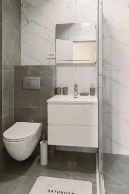a white bathroom with a toilet and a sink at Big Family apartment - 3BR in Budva