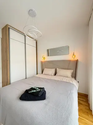 a bedroom with a bed with a black bag on it at Modern flat 5 Min to Beach in Ulcinj