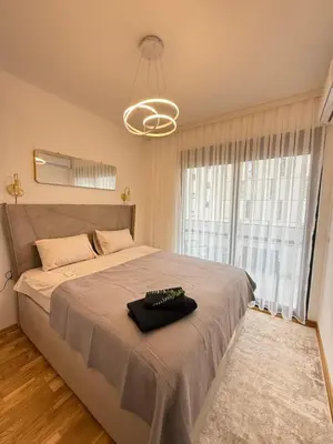 a bedroom with a large bed with a large window at Modern flat 5 Min to Beach in Ulcinj