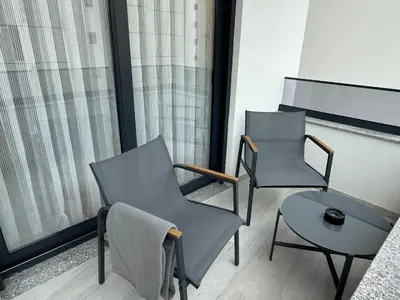 two chairs and a table on a balcony at Modern flat 5 Min to Beach in Ulcinj