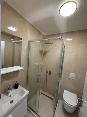 a bathroom with a shower and a toilet and a sink at Modern flat 5 Min to Beach in Ulcinj