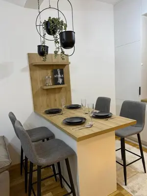 a kitchen with a table with chairs and a chandelier at Modern flat 5 Min to Beach in Ulcinj