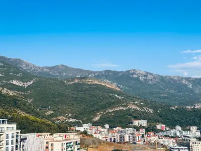 a view of a city with mountains in the background at Vuelo Sobre Bečići in Becici