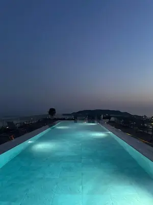 a large swimming pool with blue water at night at Vuelo Sobre Bečići in Becici