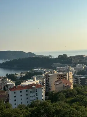 a city with buildings and the ocean in the background at Vuelo Sobre Bečići in Becici