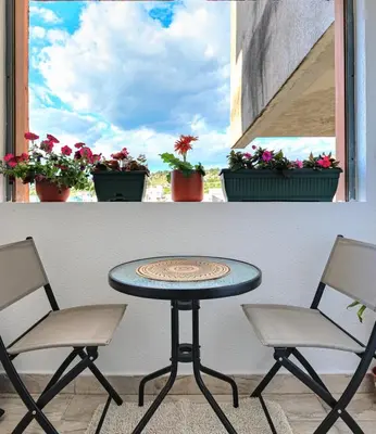 a table and two chairs in front of a window at BlueMont Apartment in Podgorica
