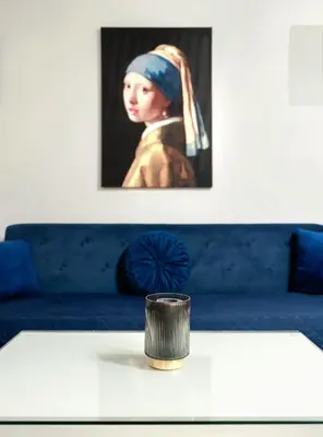 a painting of a woman sitting on a blue couch at BlueMont Apartment in Podgorica