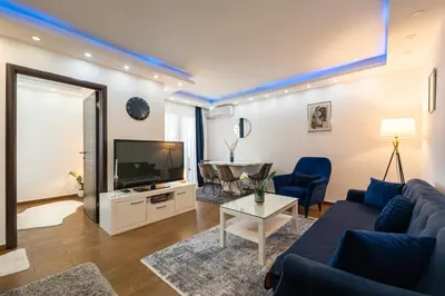 a living room with a couch and a tv at BlueMont Apartment in Podgorica