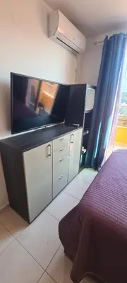 a bedroom with a bed and a flat screen tv at Sunset studio Bečići in Becici